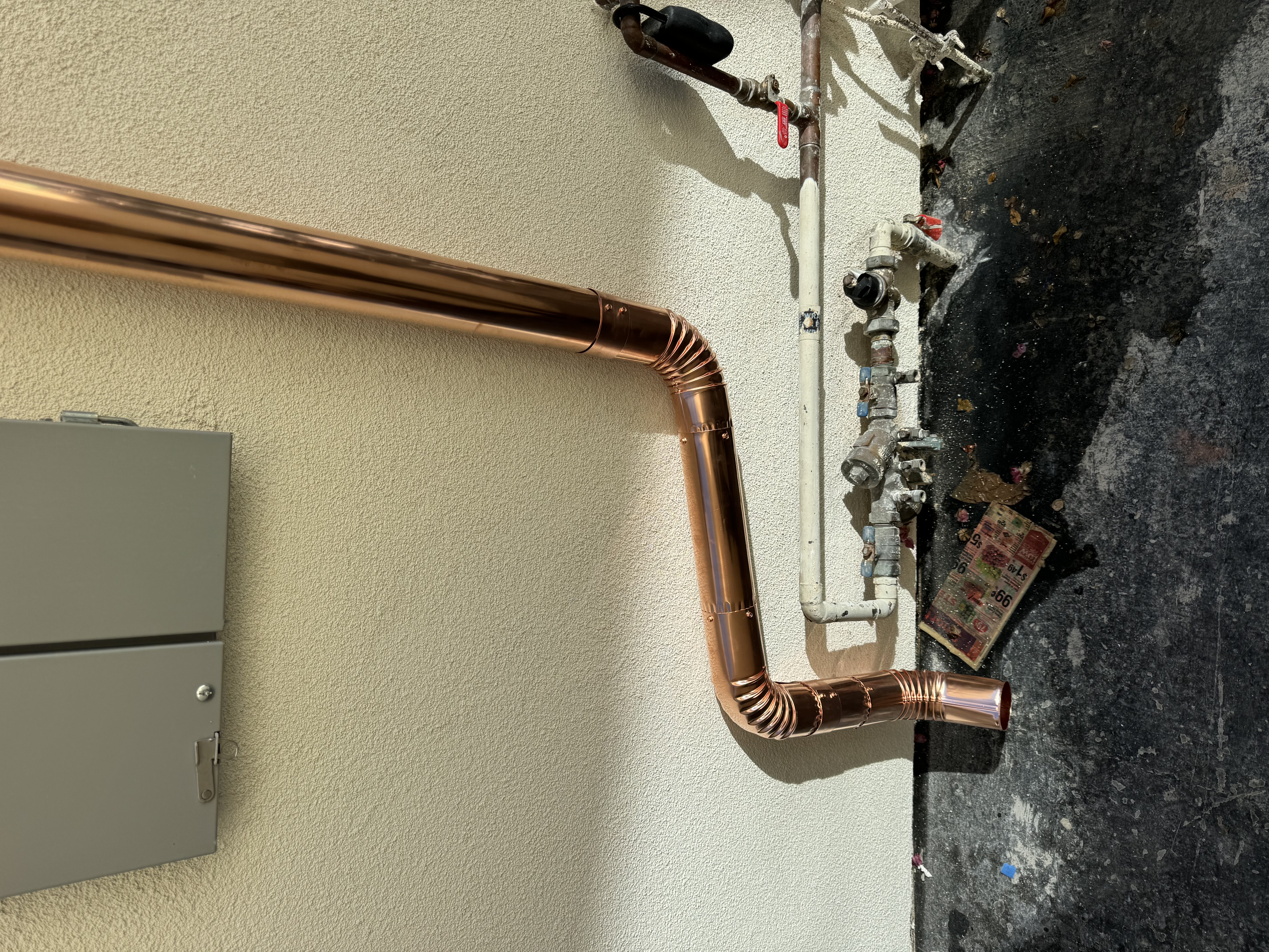 Copper downspout elbows and discharge detail