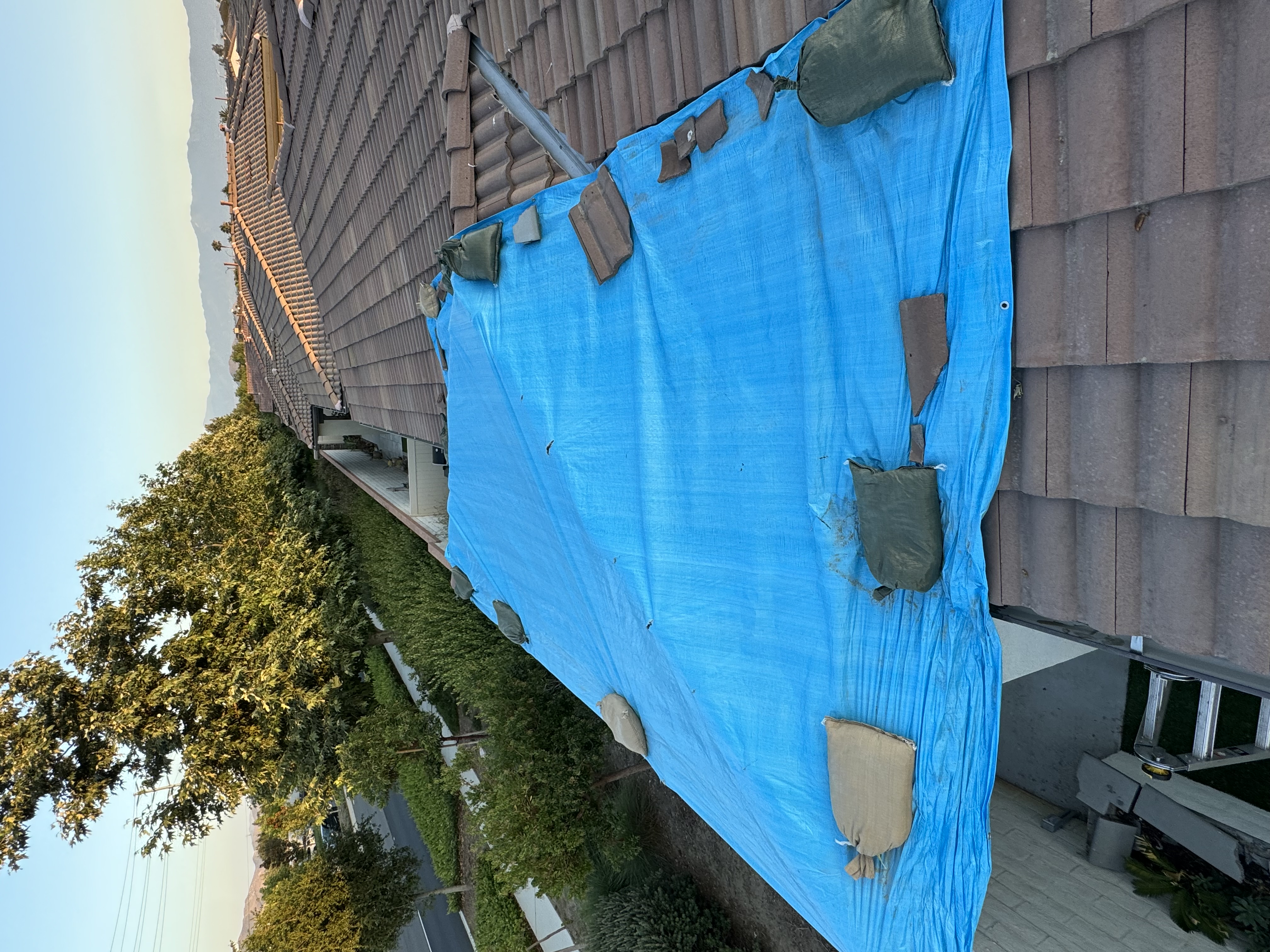 Blue tarp and sandbags on roof during repair