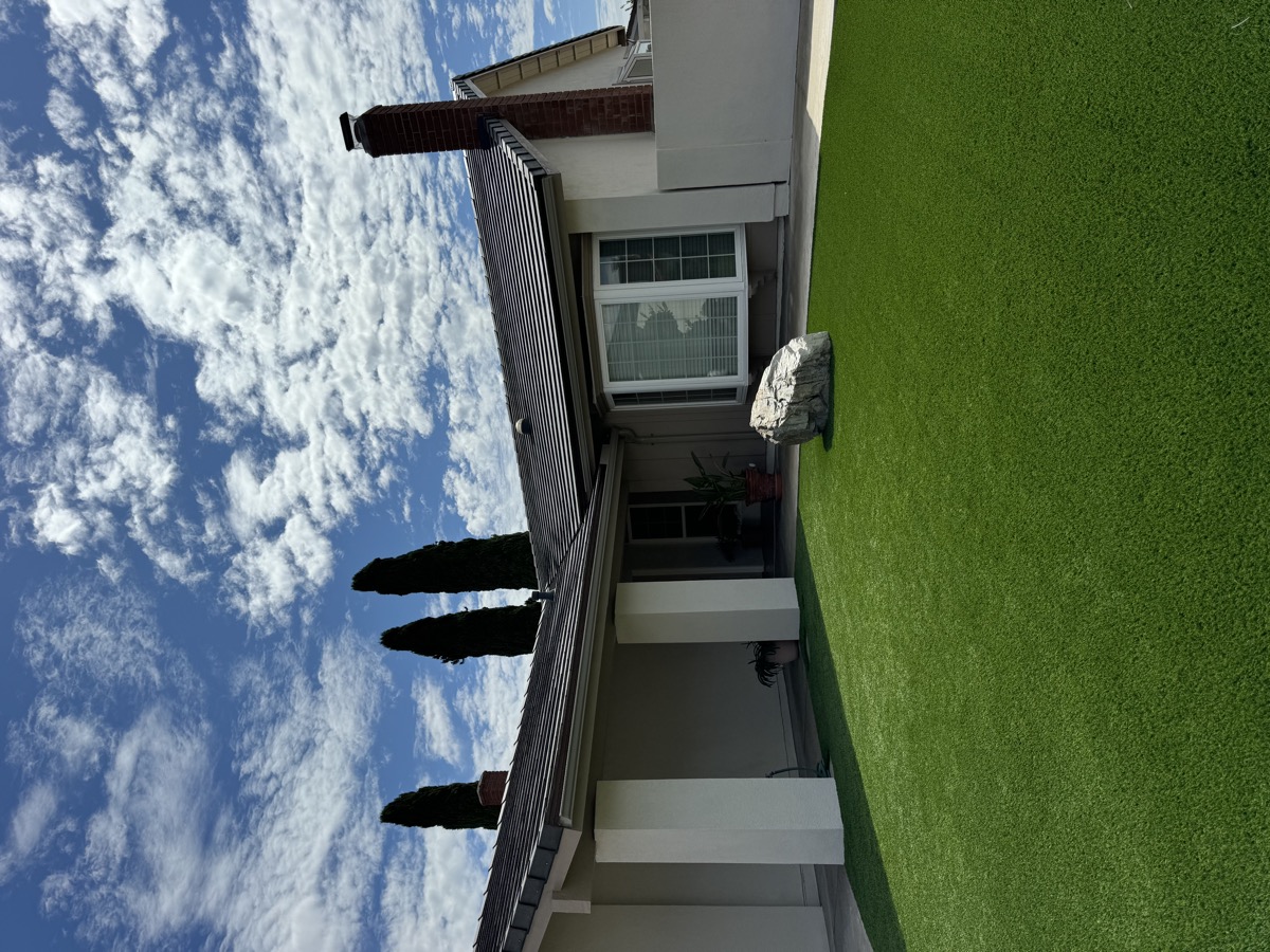 Professional gutter installation on Orange County home with manicured lawn